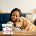 Woman hugging a golden retriever with Evo Dyne Styptic Powder jar in front